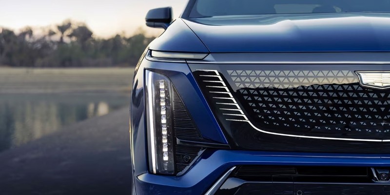 Close-up of a blue 2026 Cadillac VISTIQ front, showing a striking grille and LED headlights.