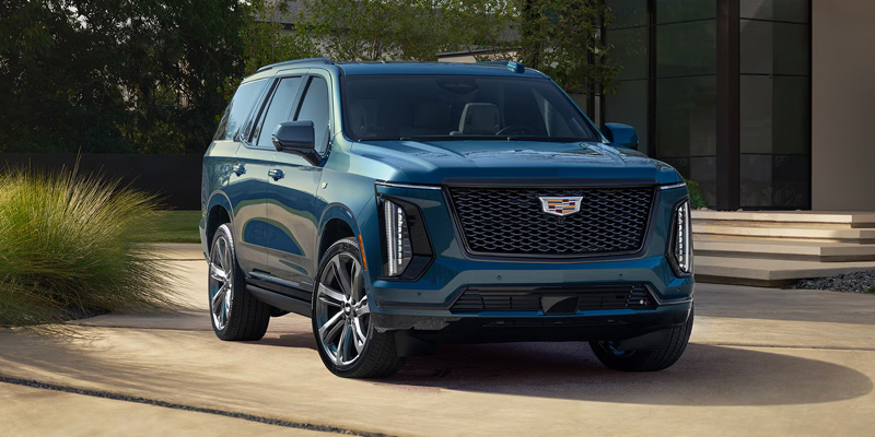 2026 Cadillac Escalade luxury SUV parked outside a modern home in Wichita Falls, TX, featuring a bold grille, sleek LED lighting, and upscale design.