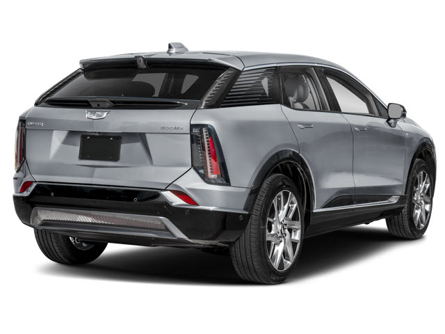A silver 2026 Cadillac OPTIQ SUV with sleek design, showing the rear side and distinctive tail lights.